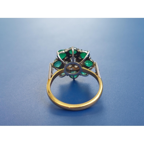 238 - An emerald & diamond set cluster ring on yellow metal shank.  Finger size N.