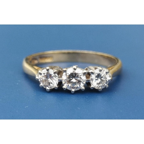 239 - A three stone diamond set 18ct gold ring.  Finger size L.