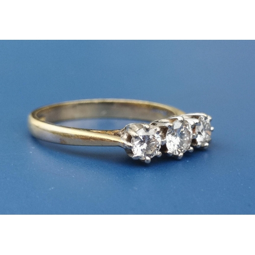 239 - A three stone diamond set 18ct gold ring.  Finger size L.