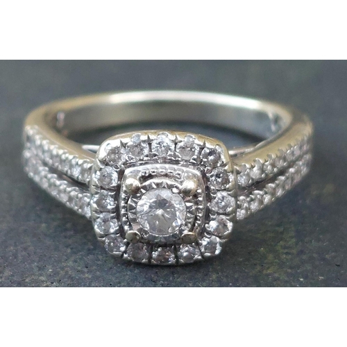 247 - A modern diamond cluster ring with twin rows of diamonds to shoulders, in 9ct white gold.  Finger si... 