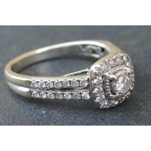 247 - A modern diamond cluster ring with twin rows of diamonds to shoulders, in 9ct white gold.  Finger si... 