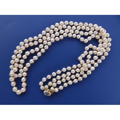 281 - A long twin strand pearl necklace, approximate pearl diameters 7.5mm, on 9ct gold cluster clasp, 31