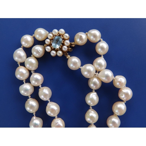 281 - A long twin strand pearl necklace, approximate pearl diameters 7.5mm, on 9ct gold cluster clasp, 31