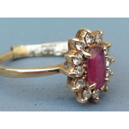 257 - An oval ruby & diamond cluster ring in 9ct gold.