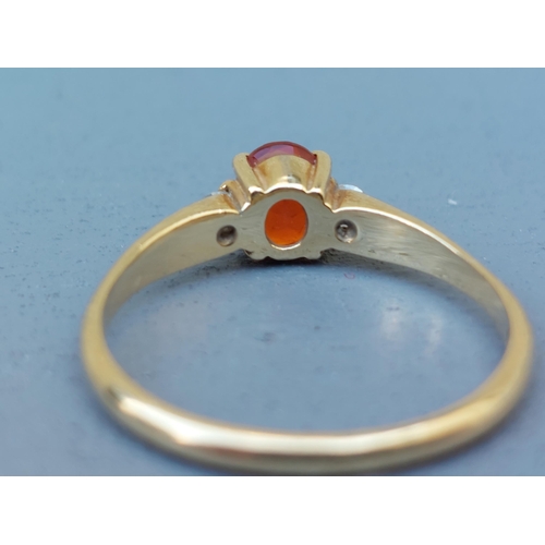 259 - A small Mexican fire opal & diamond three stone ring on 18ct gold shank.  Finger size Q.