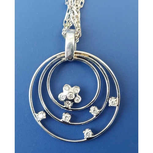 294 - A modern 18ct white gold concentric hoop pendant necklace set with small diamonds, the pendant 1