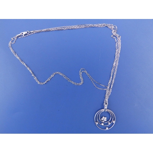 294 - A modern 18ct white gold concentric hoop pendant necklace set with small diamonds, the pendant 1