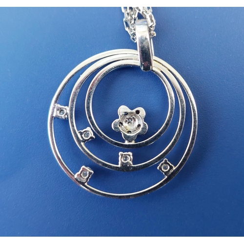 294 - A modern 18ct white gold concentric hoop pendant necklace set with small diamonds, the pendant 1