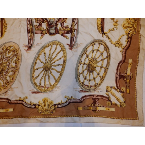 44 - A silk Hermes headscarf - Gun carriage with wheel devices in brown and gold on cream ground, designe... 