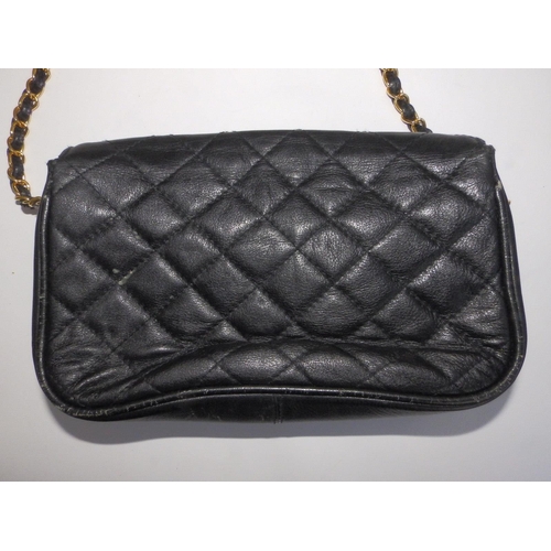 61 - A Chanel quilted black leather shoulder bag, bold interlaced C's to flap, on gilt metal & leather st... 