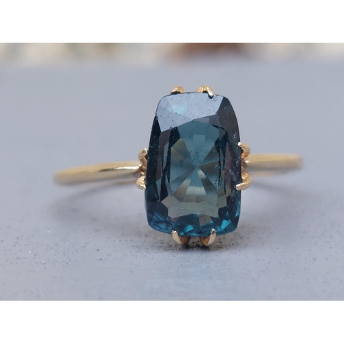 150 - A natural blue spinel solitaire ring on yellow metal shank testing as 18ct gold.  Finger size Q/R.