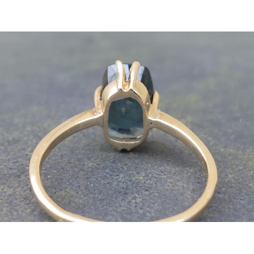 150 - A natural blue spinel solitaire ring on yellow metal shank testing as 18ct gold.  Finger size Q/R.