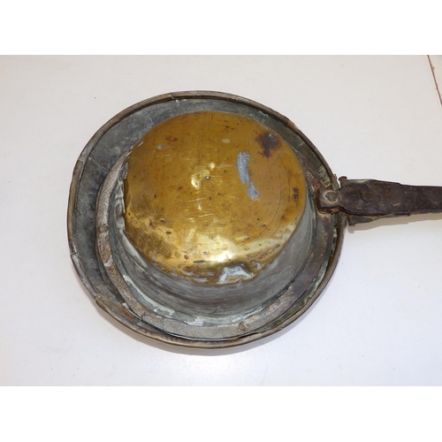 81 - An antique brass warming pan with iron strap handle, the pan pricked with a geometric floral design,... 