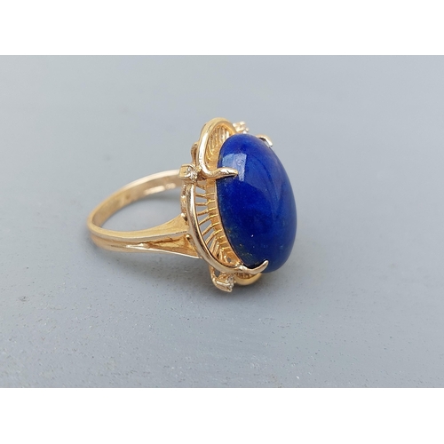 160 - A 14ct gold dress ring set with a lapis cabochon and four small diamonds.  Finger size M.