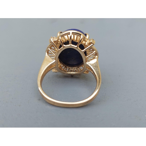 160 - A 14ct gold dress ring set with a lapis cabochon and four small diamonds.  Finger size M.