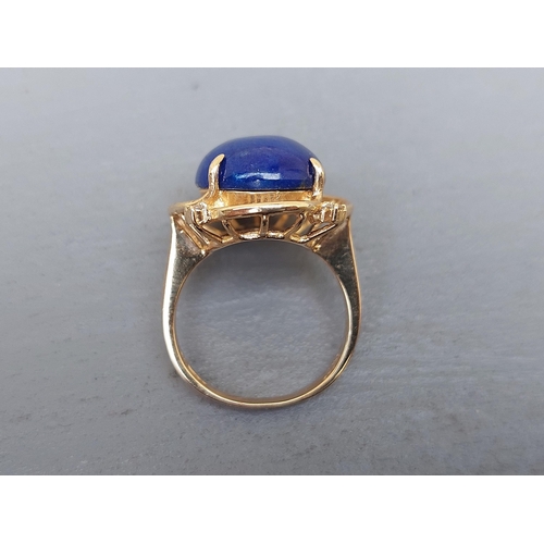 160 - A 14ct gold dress ring set with a lapis cabochon and four small diamonds.  Finger size M.