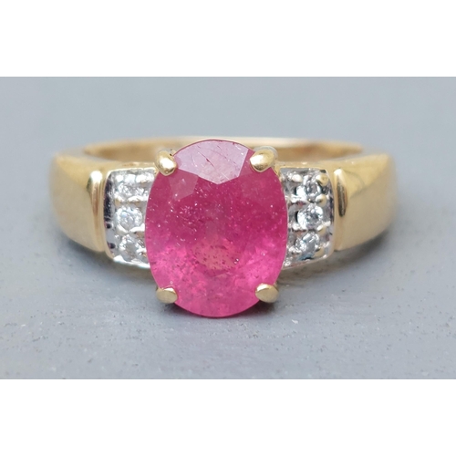 161 - A modern ruby & diamond set 18ct gold ring, having oval cut ruby to centre.  Finger size J.