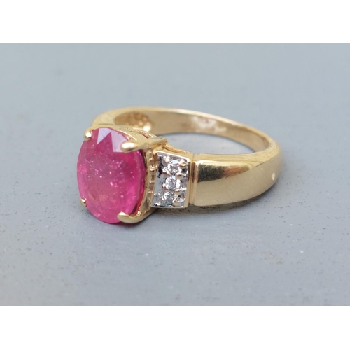 161 - A modern ruby & diamond set 18ct gold ring, having oval cut ruby to centre.  Finger size J.