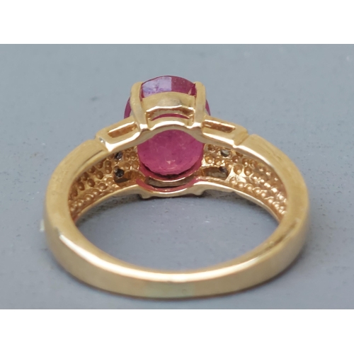 161 - A modern ruby & diamond set 18ct gold ring, having oval cut ruby to centre.  Finger size J.