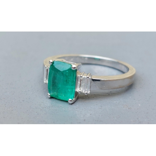 162 - A modern emerald & diamond ring, the rectangular cut emerald flanked by four small baguette diamonds... 