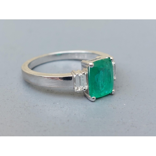 162 - A modern emerald & diamond ring, the rectangular cut emerald flanked by four small baguette diamonds... 