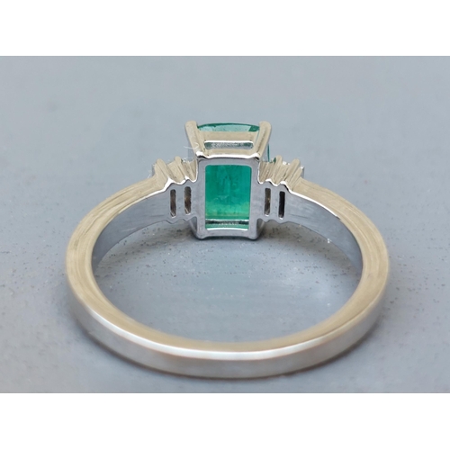 162 - A modern emerald & diamond ring, the rectangular cut emerald flanked by four small baguette diamonds... 