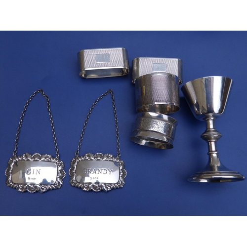 107 - A pair of Sheffield silver spirit labels, a small London chalice and four silver napkin rings. (7)