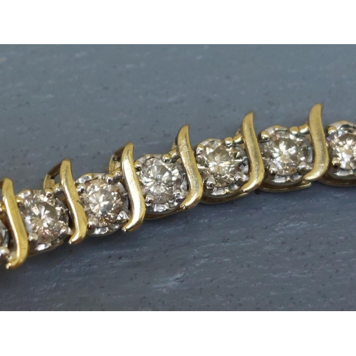 167 - A diamond line bracelet in 10k yellow metal, total diamond weight approximately 4 carats, 7.2