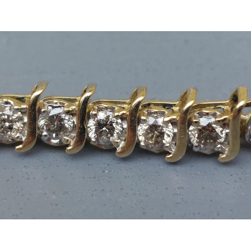 167 - A diamond line bracelet in 10k yellow metal, total diamond weight approximately 4 carats, 7.2