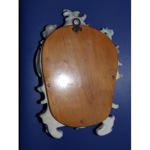 28 - A small Meissen rococo style wall mirror modelled with figures.