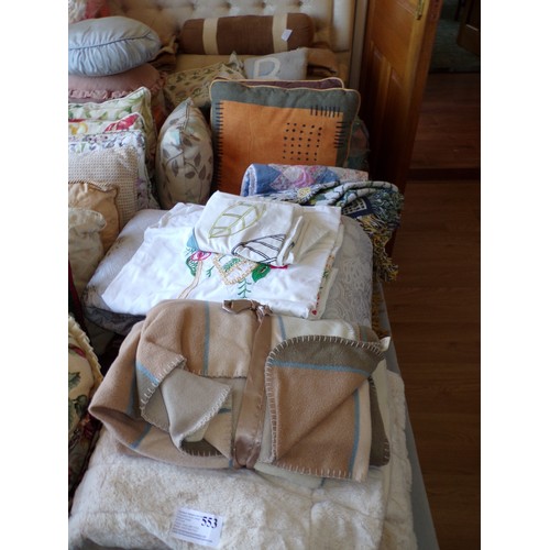 553 - ROW OF BED COVERS, CUSHIONS ETC.