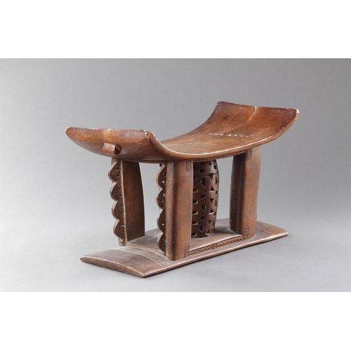 607 - AN OLD EXAMPLE OF AN ASHANTI STOOL GHANA, 19TH CENTURY 32cm high, 54.5cm wide Together with another ... 