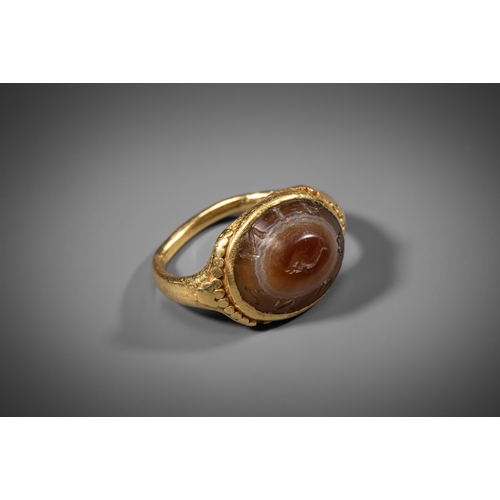 649 - AN ANCIENT ROMAN GOLD AND AGATE INTAGLIO RING 2nd - 3rd Century ADThe oval agate panel with a centra... 