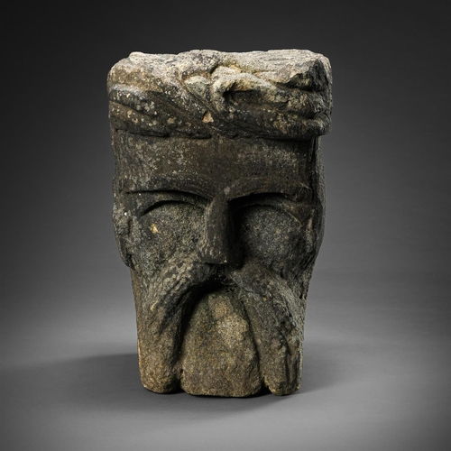 671 - A CARVED STONE CORBEL HEAD 14TH/15TH CENTURY Dark hardstone male face- projecting scrolling hairline... 