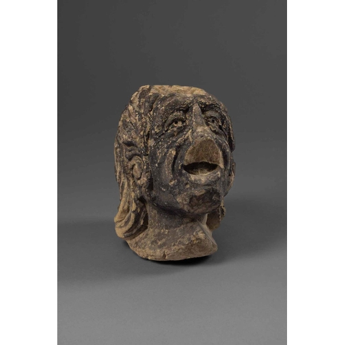 677 - A CARVED DARK SANDSTONE HEAD OF A WOMAN, ONCE A GARGOYLE/SPOUTENGLISH, MEDIEVALWith recess to top po... 