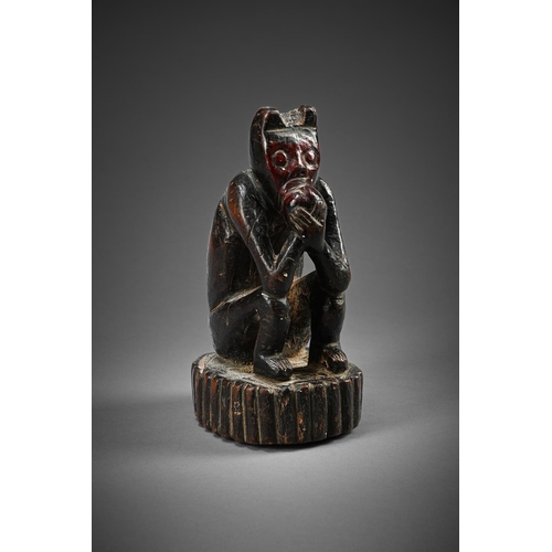 754 - A SEATED 'MONKEY' EATING FRUITSOUTH AMERICAN, POSSIBLY PERUVIAN, PROBABLY EARLY 19TH CENTURYRed face... 