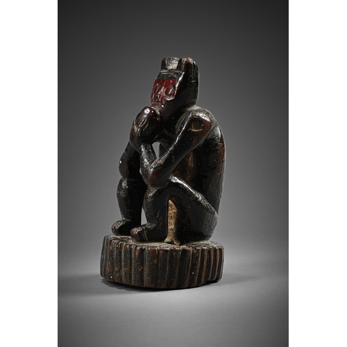 754 - A SEATED 'MONKEY' EATING FRUITSOUTH AMERICAN, POSSIBLY PERUVIAN, PROBABLY EARLY 19TH CENTURYRed face... 