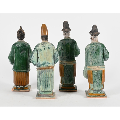 766 - FOUR CHINESE POTTERY FIGURES OF ATTENDANTSMING DYNASTYIn green and okra glazes and white painted det... 