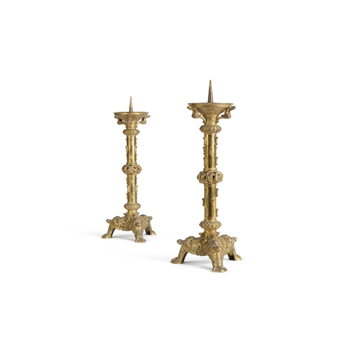 128 - A PAIR OF GILT BRASS PRICKET CANDLESTICKS IN THE MEDIEVAL STYLE LATE 19TH CENTURY, IN THE MANNER OF ... 