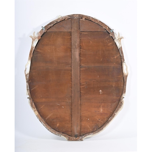 578 - A CARVED AND PAINTED OVAL MIRROR 20TH CENTURYThe frame of naturalistic branch form135cm high, 110cm ... 