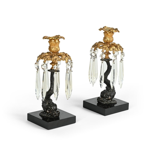 594 - A PAIR OF BRONZE TABLE LUSTRE CANDLESTICKS 19TH CENTURYEach sconce above a hung collar and on dolphi... 