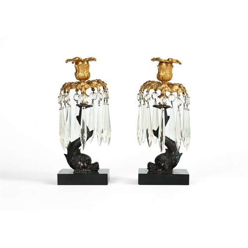 594 - A PAIR OF BRONZE TABLE LUSTRE CANDLESTICKS 19TH CENTURYEach sconce above a hung collar and on dolphi... 