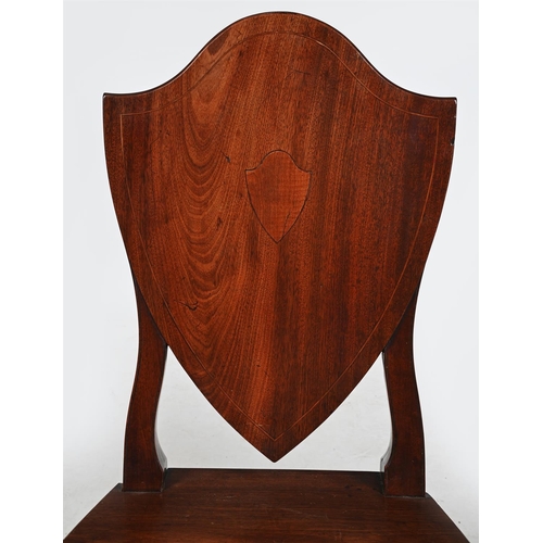 304 - A PAIR OF GEORGE III MAHOGANY SHIELD BACK HALL CHAIRSCIRCA 1790The line inlaid backs centred with a ... 