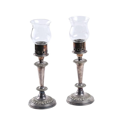 387 - A PAIR OF SILVER-PLATED CANDLESTICKS19TH CENTURY AND LATERNow fitted with storm mounts and glass sha... 