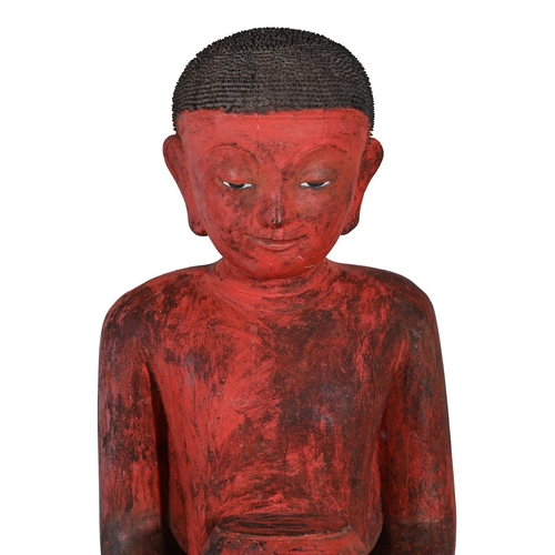 650 - A LARGE CAMBODIAN STANDING MONKModelled holding a bowl, red paintedapproximately 160cm high Provenan... 