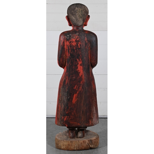 650 - A LARGE CAMBODIAN STANDING MONKModelled holding a bowl, red paintedapproximately 160cm high Provenan... 