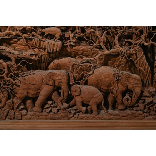 687 - A VERY LARGE SOFTWOOD PANEL OF ELEPHANTS IN A JUNGLETHAILAND, 20TH CENTURYDiorama of elephants, buff... 