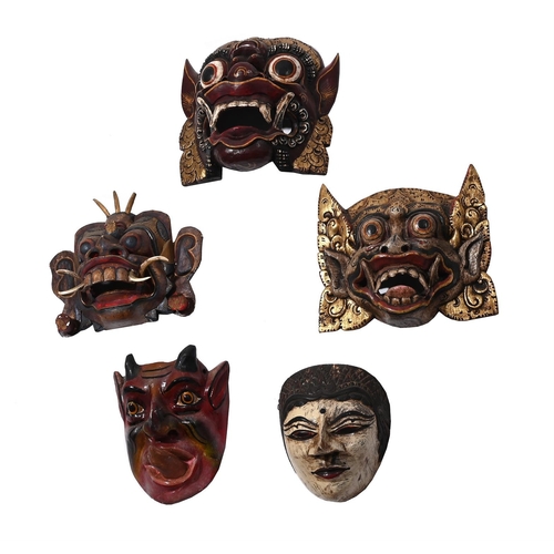 722 - A GROUP OF FIVE CARVED AND PAINTED DECORATIVE MASKS 20TH CENTURYComprising of three Balinese masks, ... 