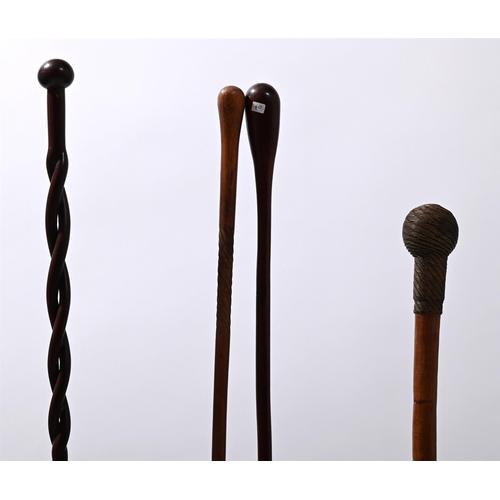 744 - FOUR CARVED WOODEN WALKING STICKSZULU, CONTEMPORARYAll with metal display standsstick length ranging... 