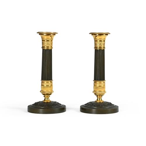 17 - A PAIR OF ORMOLU AND PATINATED BRONZE CANDLESTICKS IN CHARLES X STYLE, 19TH CENTURYeach 21cm high, 1... 